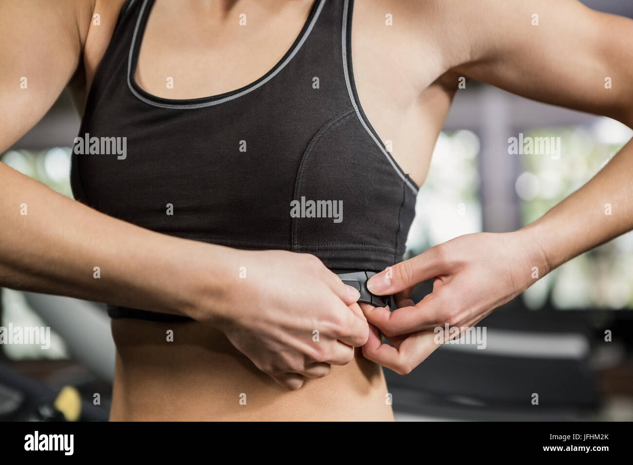 Woman in gym wearing heart rate monitor around her chest Stock Photo