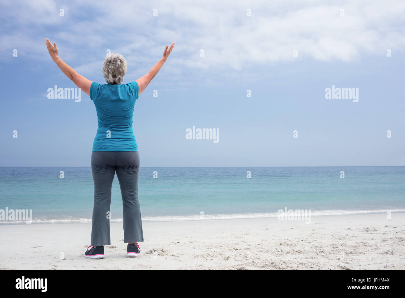 Rear view of senior woman standing on the beach Stock Photo - Alamy