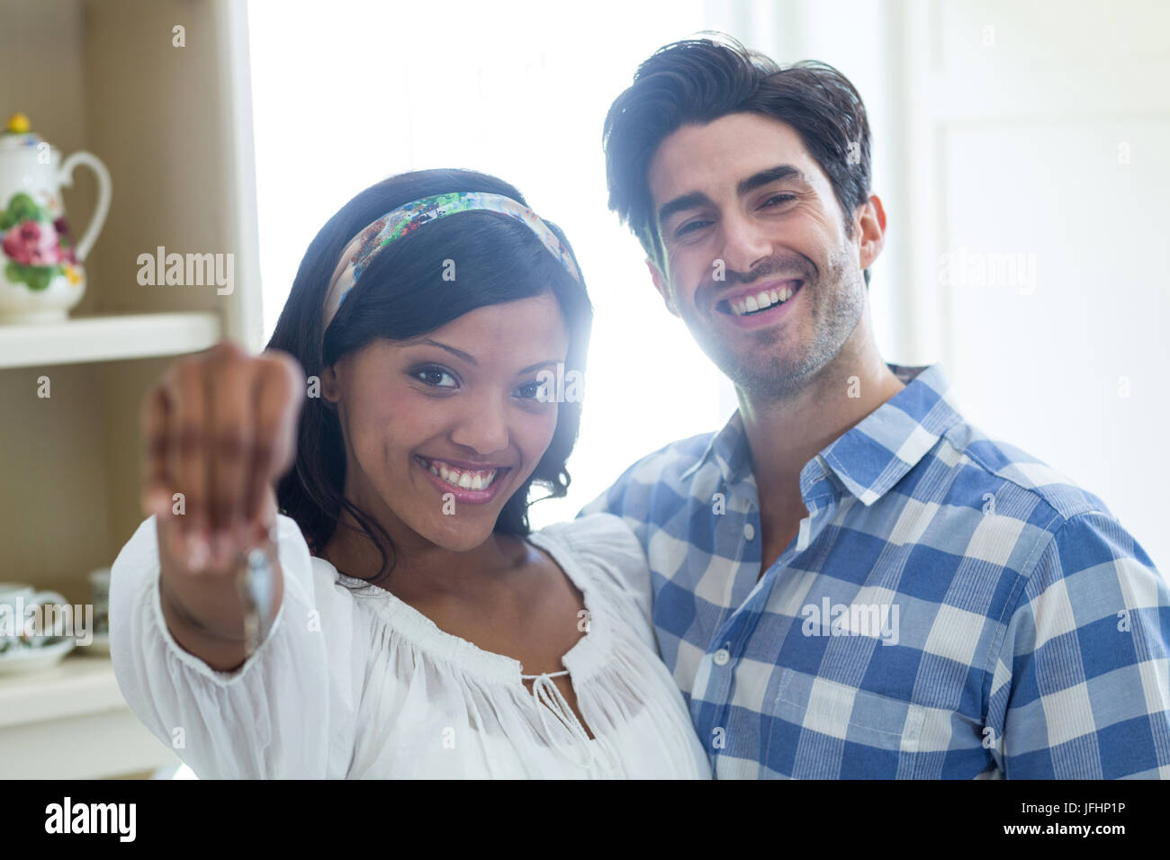 Happy young couple showing a key of their new house Stock Photo - Alamy