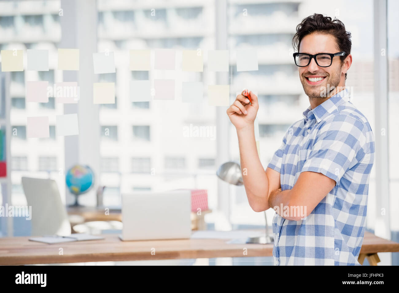 Portrait of businessman writing on sticky notes in office Stock Photo ...