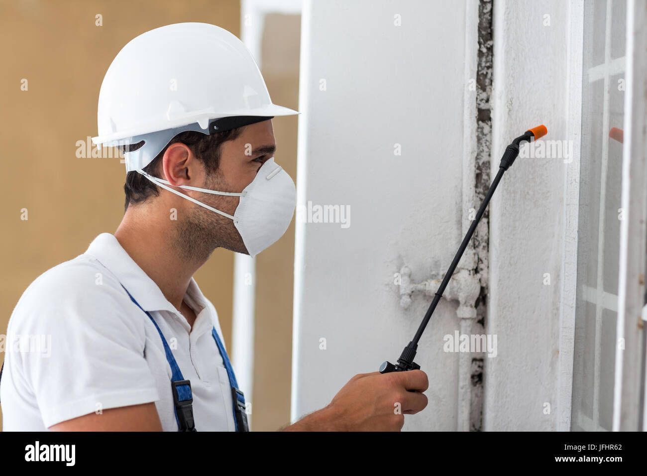 Side view of manual worker spraying pesticide Stock Photo