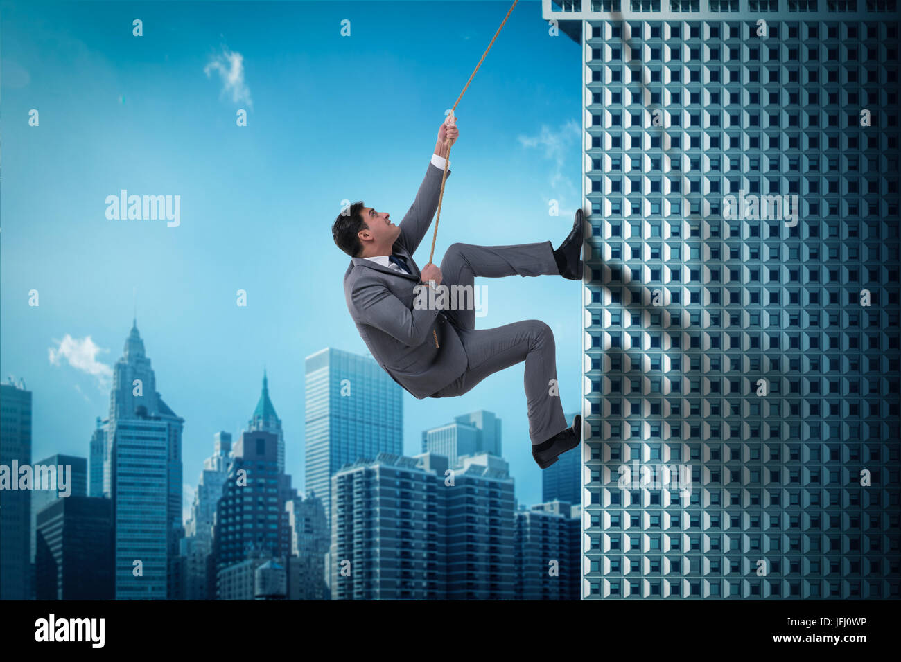 Businessman in challenge concept climbing skyscraper Stock Photo