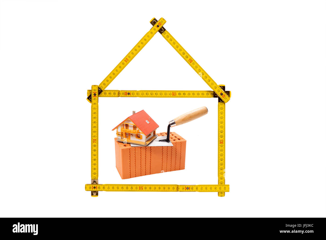 House from yard stick with clay brick as an icon for construction industry Stock Photo