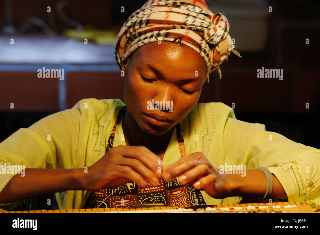 Damara girl dora while threading a chain hires stock photography and