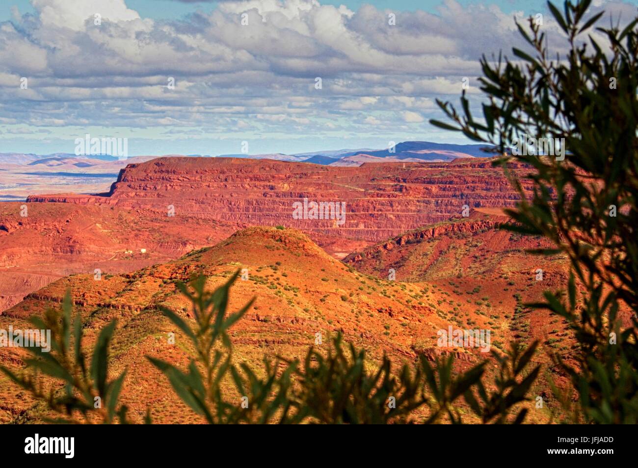 View of Mount Tom Price iron ore mine with wide, cloudy sky above Stock