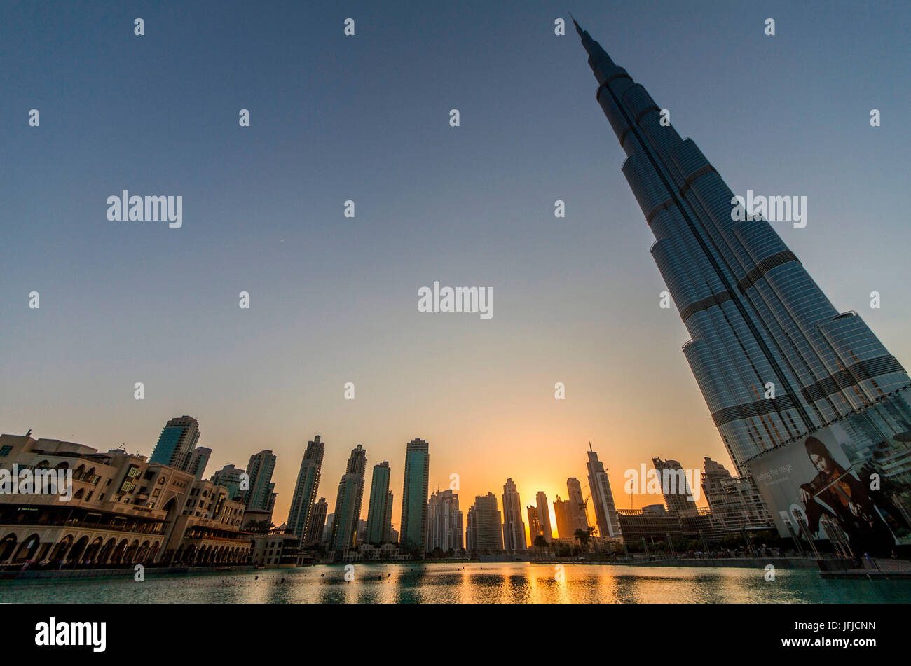 The Burj Khalifa skyscraper, its lake and the skyline of Dubai at the sunset, United Arab Emirates Stock Photo