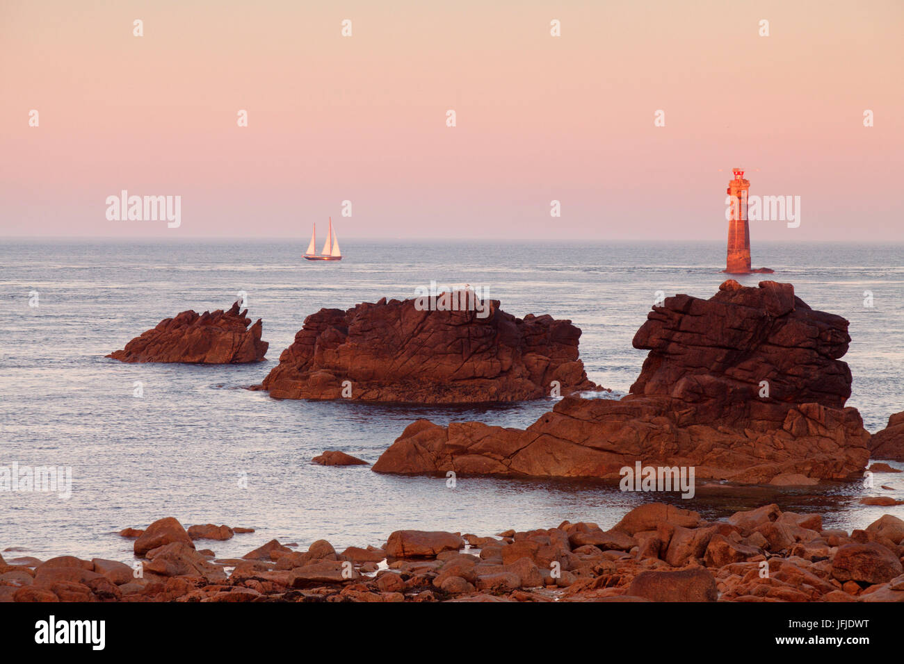 The Jument lighthouse at sunrise, off the island of Ouessant, France, Stock Photo