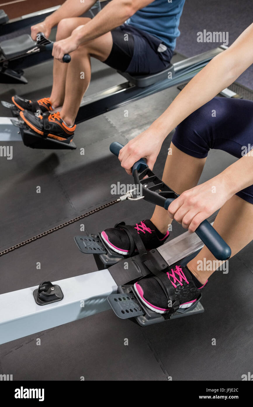 Mid section of people exercising on rowing machine Stock Photo
