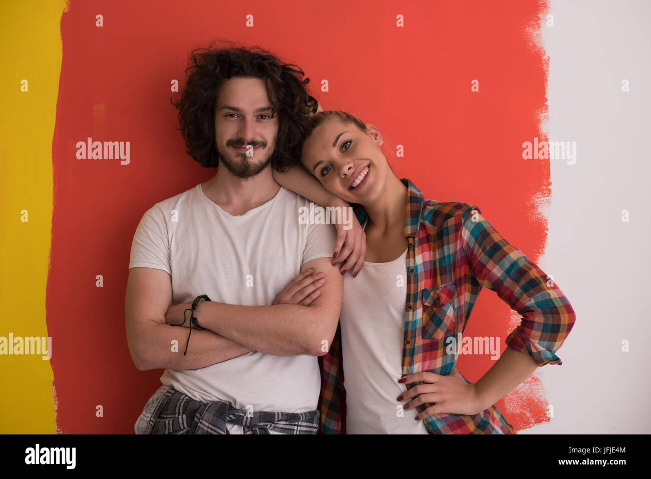 Portrait of a happy young smiling couple in love over color background ...