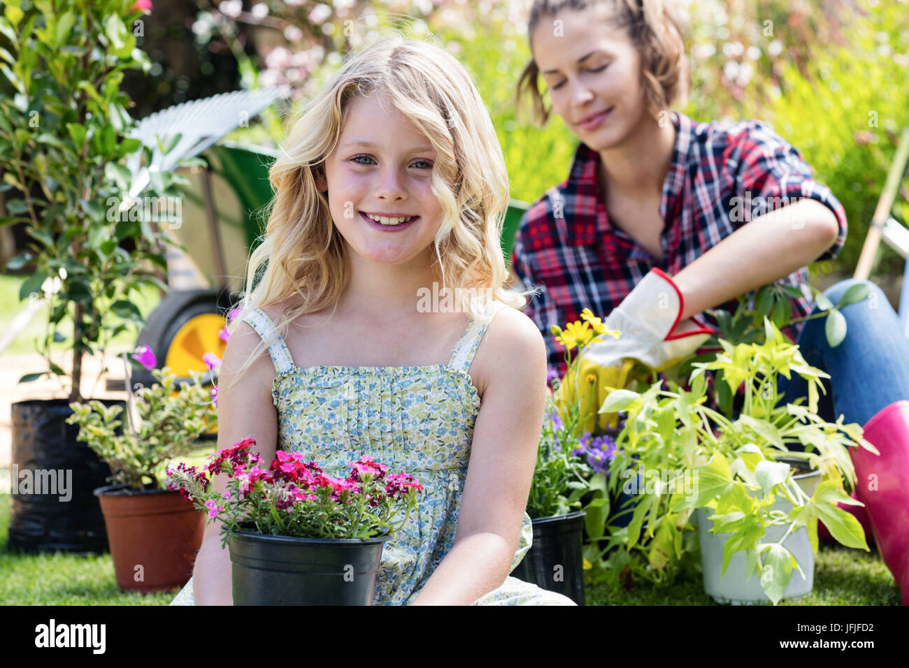 Portrait of girl sitting in garden with flower pot Stock Photo - Alamy
