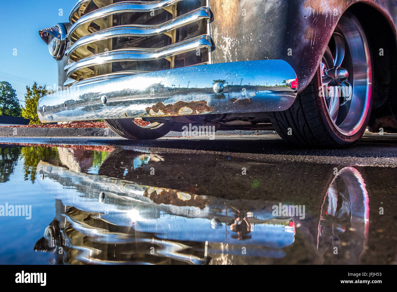 pick up truck and its grille reflecting in puddle Stock Photo