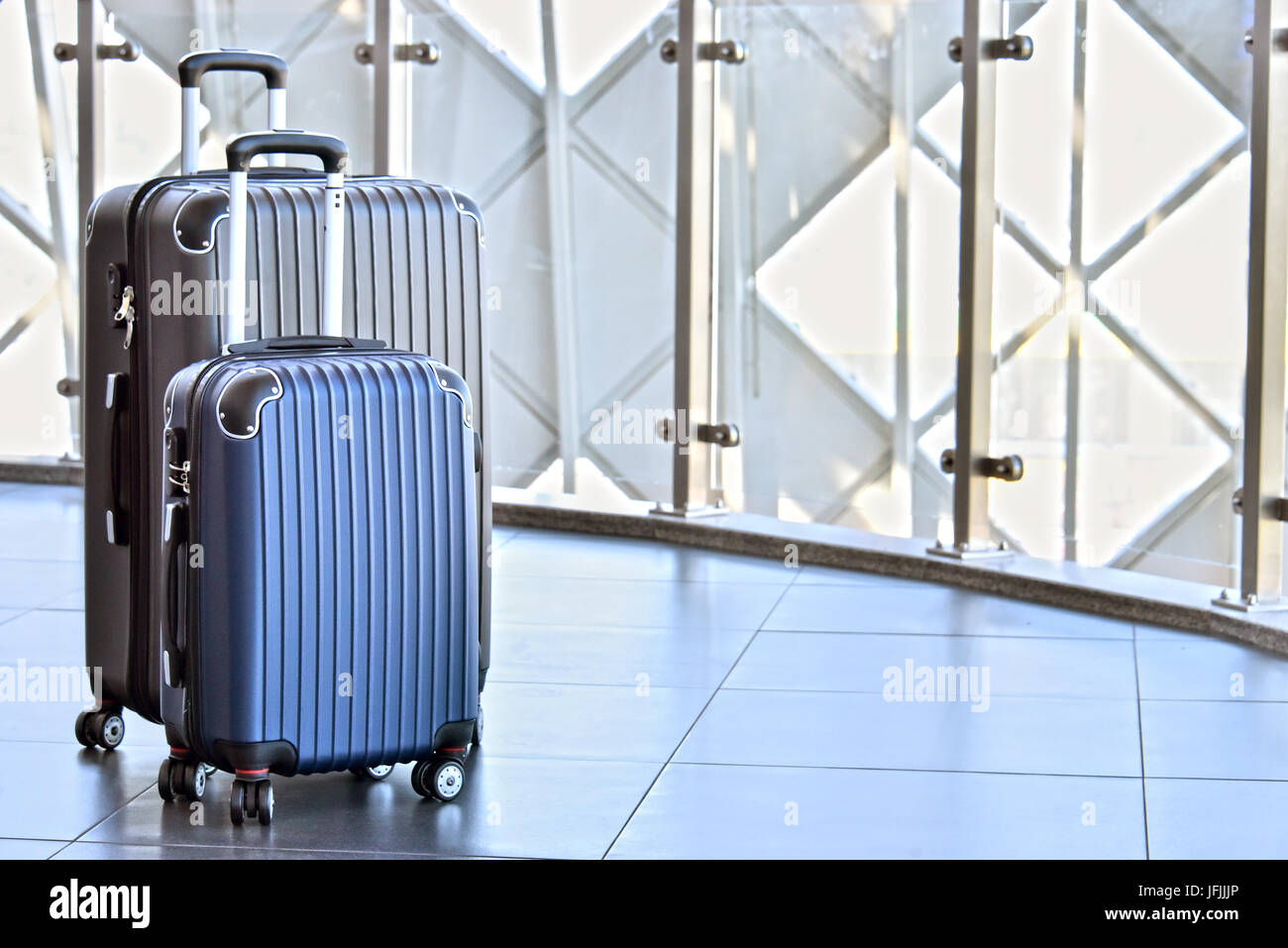 Two plastic travel suitcases in the airport hall Stock Photo Alamy