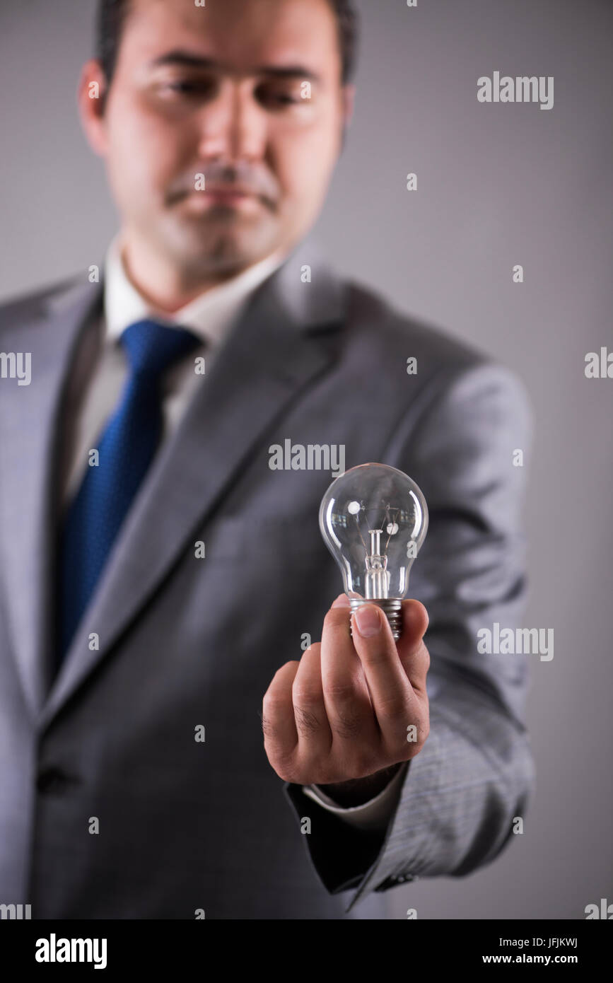 The businessman holding light bulb in creativity concept Stock Photo ...