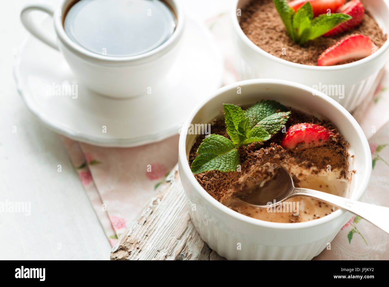 Tiramisu with strawberry and mint in the ramekins on the white table horizontal Stock Photo