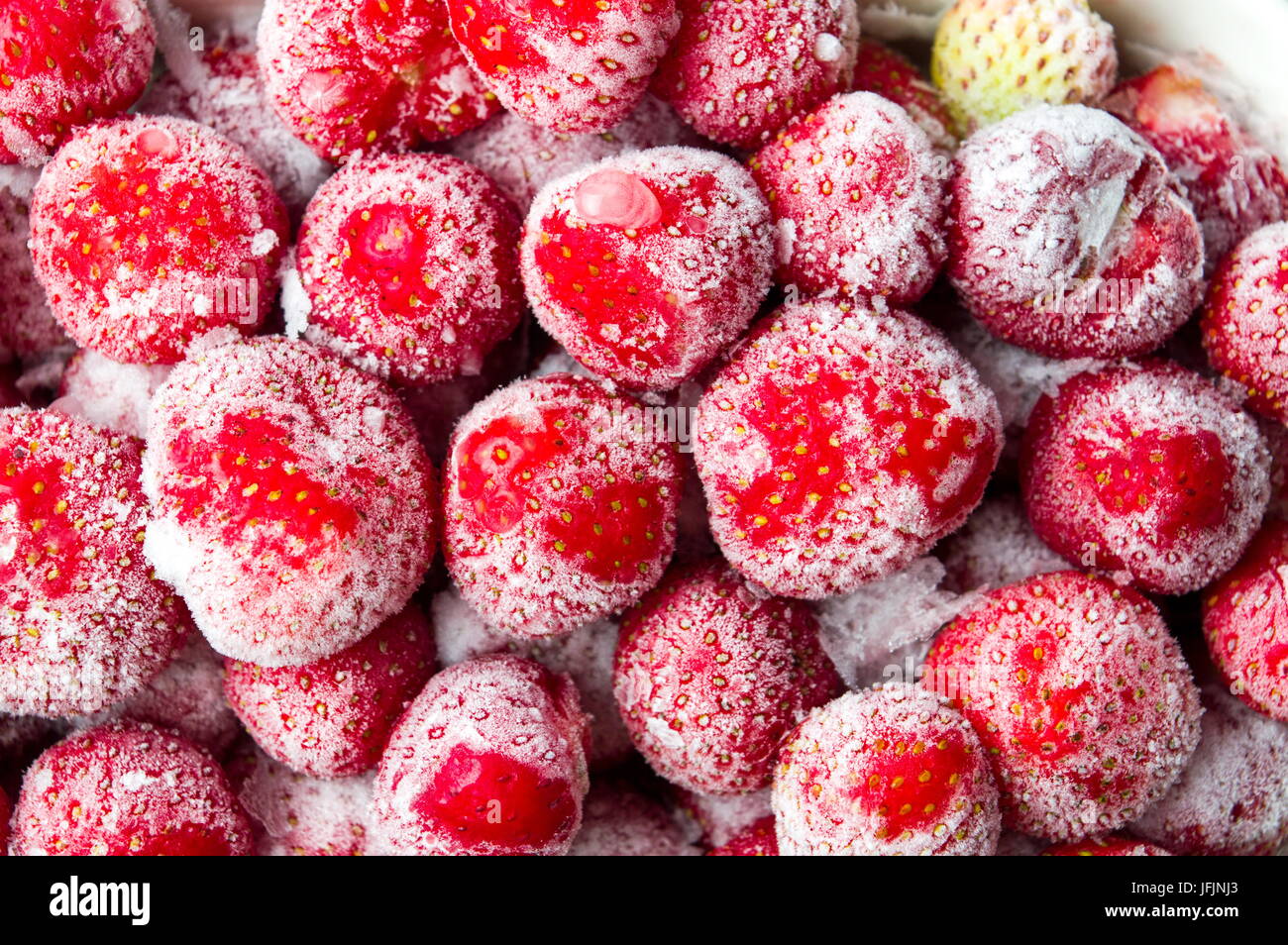 Frozen strawberries with ice crystals background pattern Stock Photo
