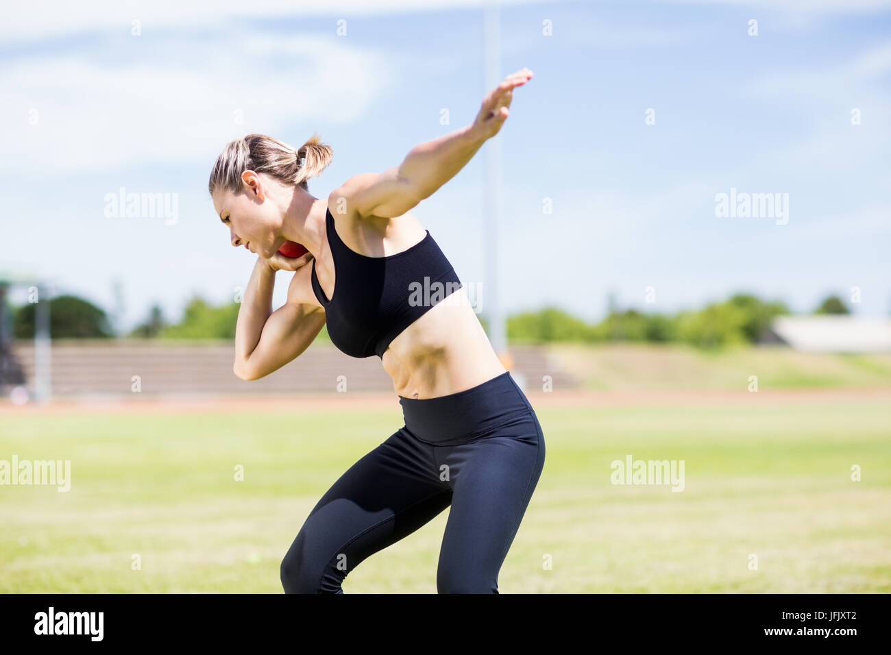 Female athlete preparing to throw shot put ball Stock Photo