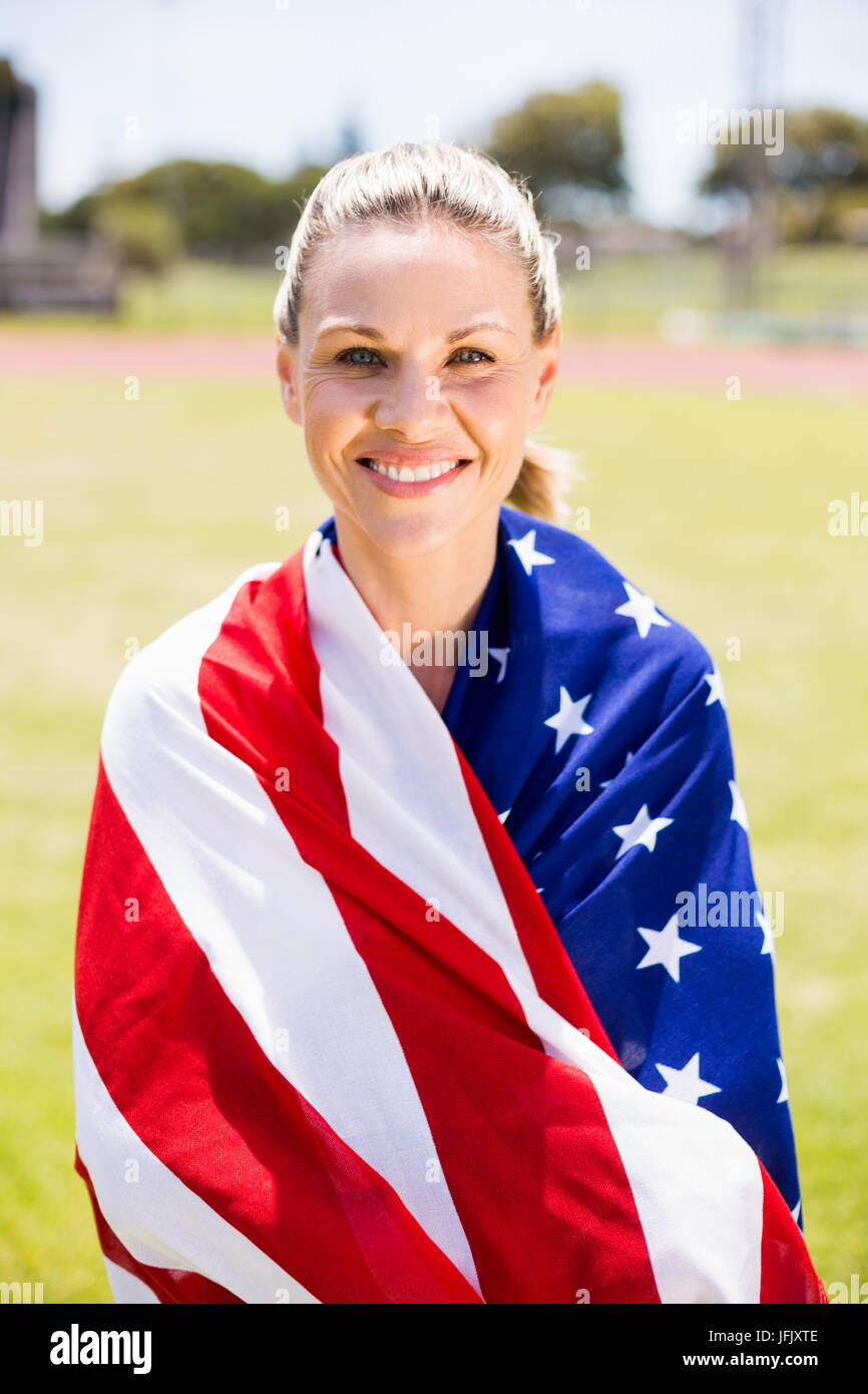 Portrait of female athlete wrapped in american flag Stock Photo - Alamy