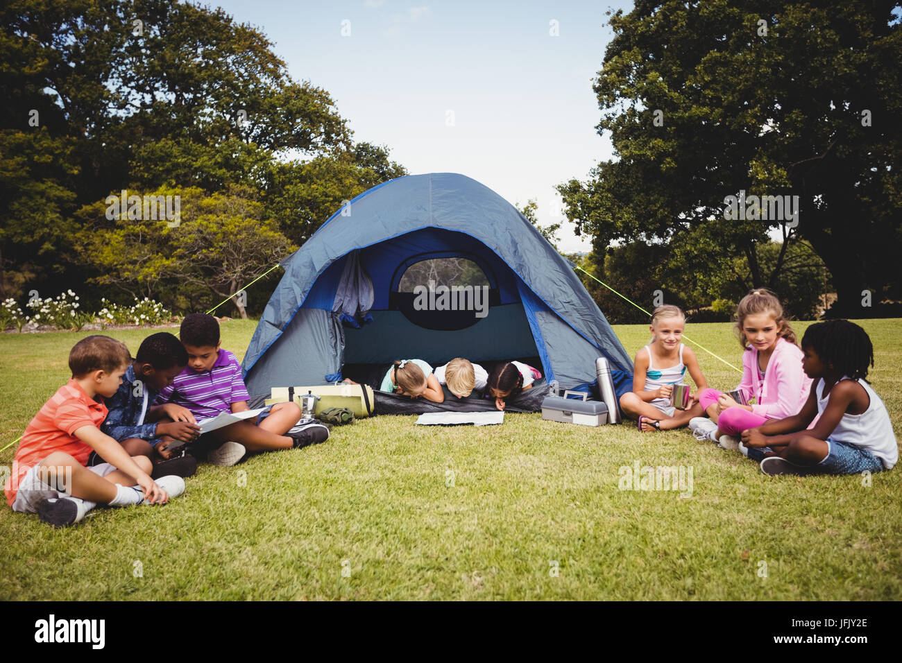 Sisters spending time in a tent on camping. Children using tablet playing games  online during summer vacation - a Royalty Free Stock Photo from Photocase