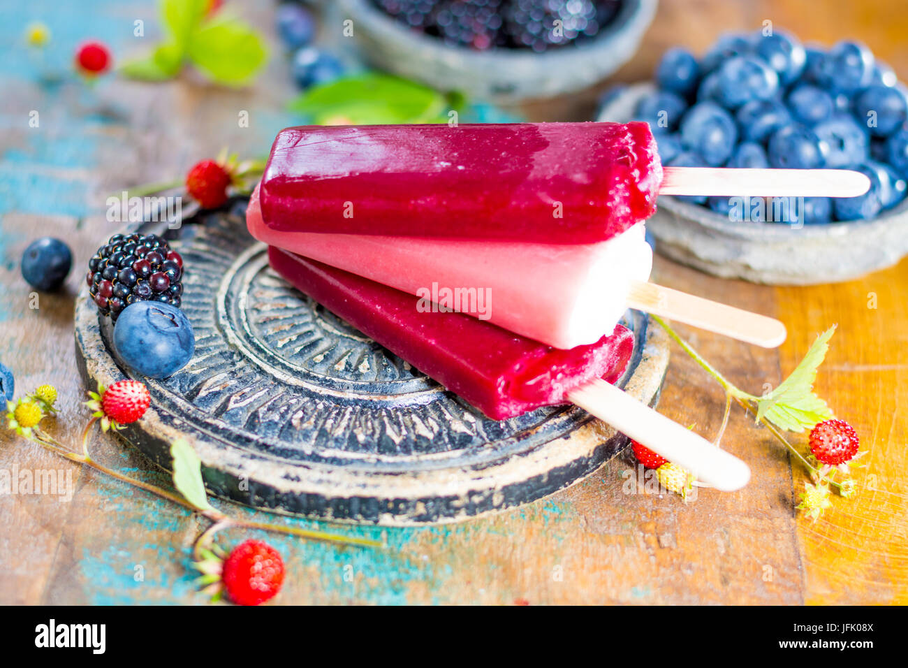 Fresh summer wild blueberries and  bramble berry, strawberry and home made sorbet ice cream popsicles. Stock Photo