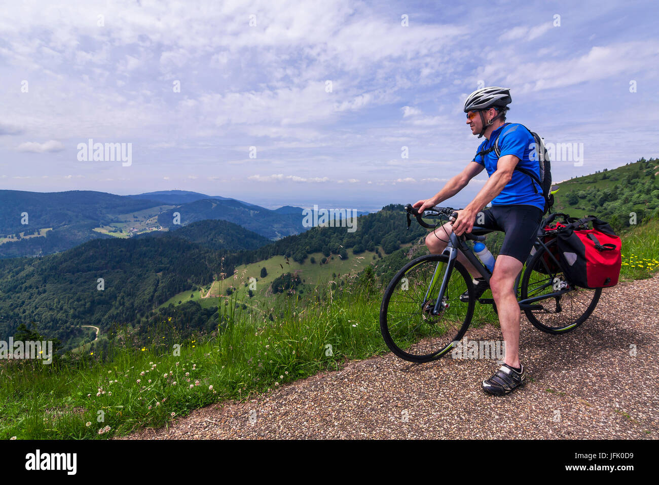 Man sitting on bicycle looking at mountains Stock Photo
