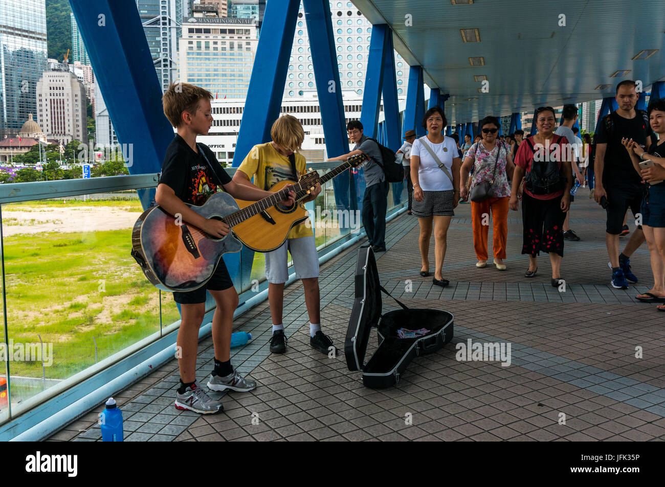 Young Caucasian buskers, street musicians, playing guitars in Hong Kong China Stock Photo