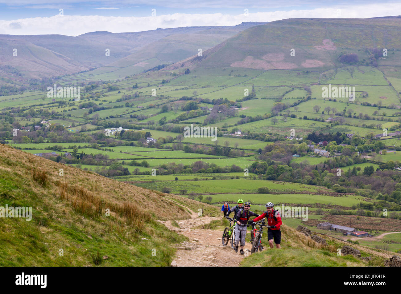 A group of mountain bikers climb to The Great Ridge between Mam Tor and Lose Hill from the Vale of Edale in the Peak District, Derbyshire, England, UK Stock Photo