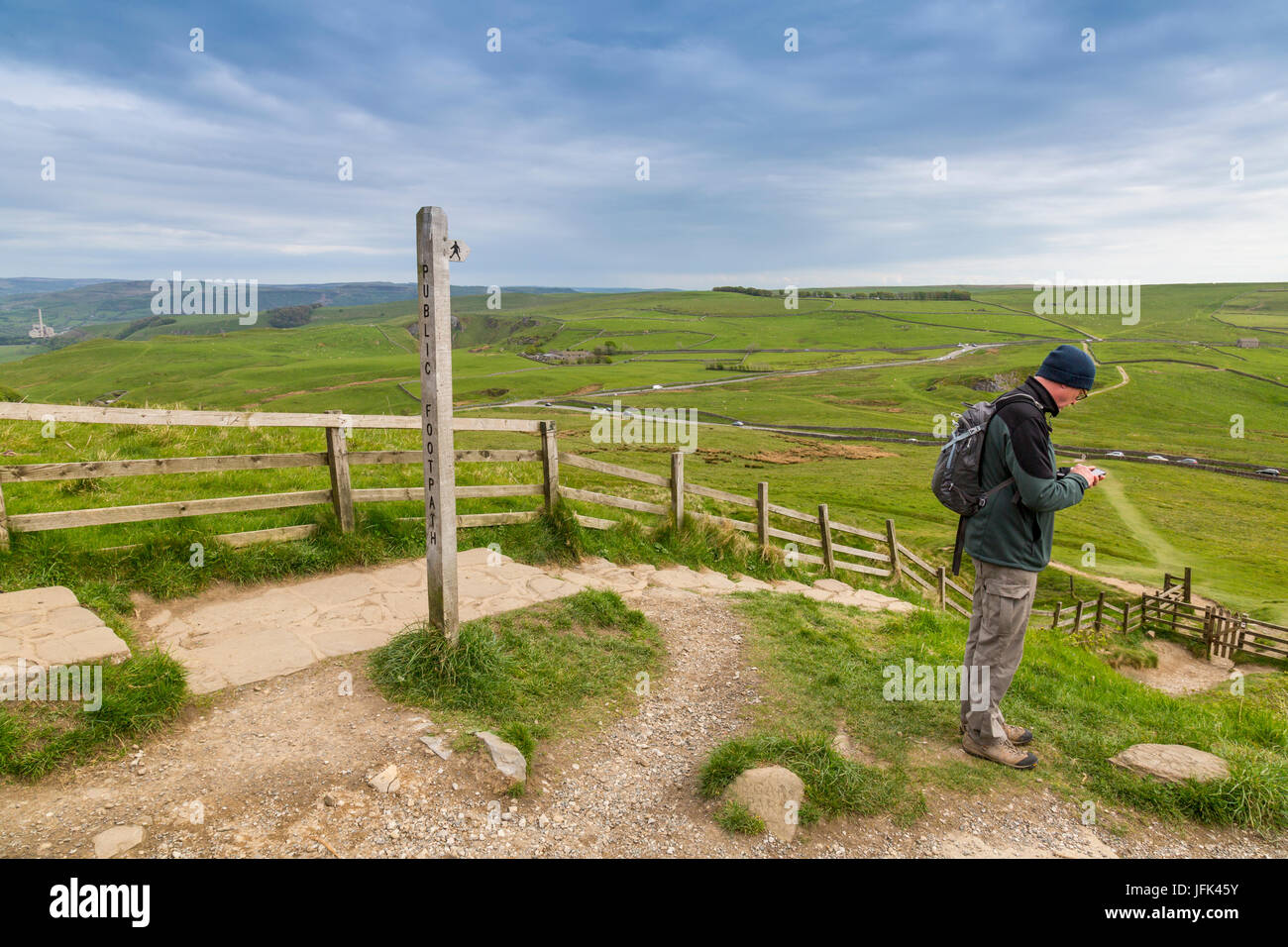 A walker checking his postion with a GPS phone app below Mam Tor in the Peak District, Derbyshire,  England, UK Stock Photo