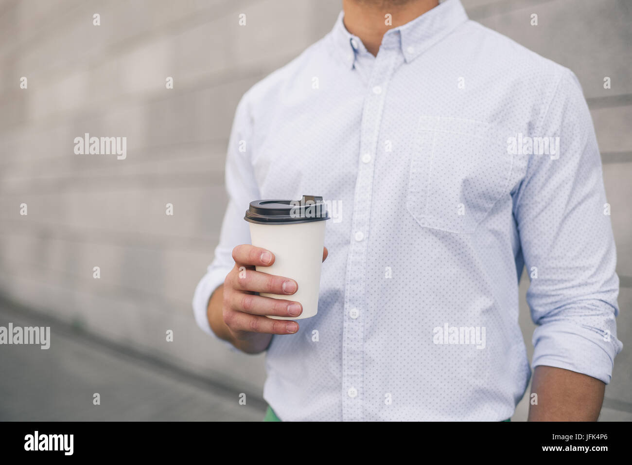 Closeup view of a hand of business man holding a coffee cup. A young ...