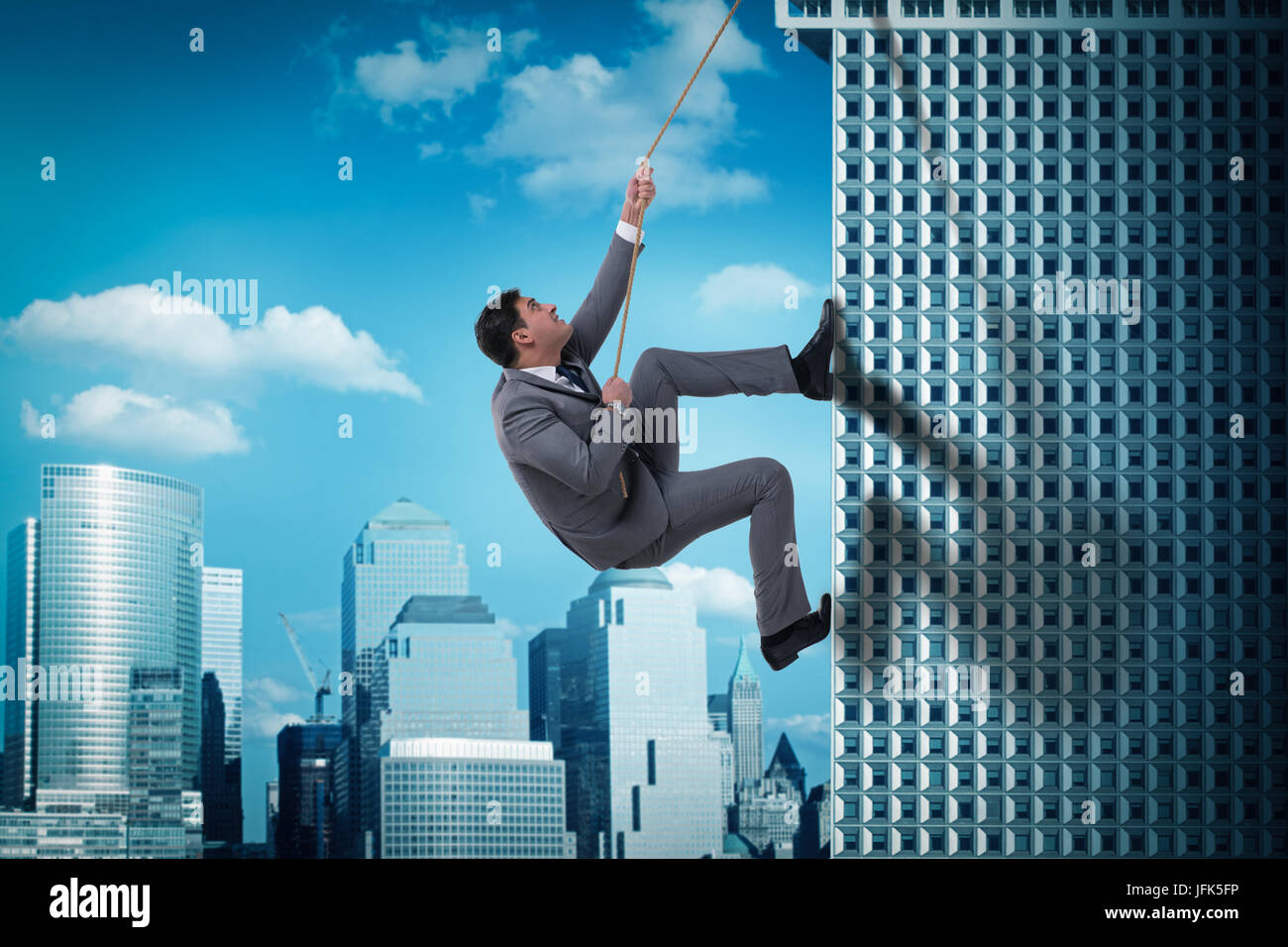 Businessman in challenge concept climbing skyscraper Stock Photo