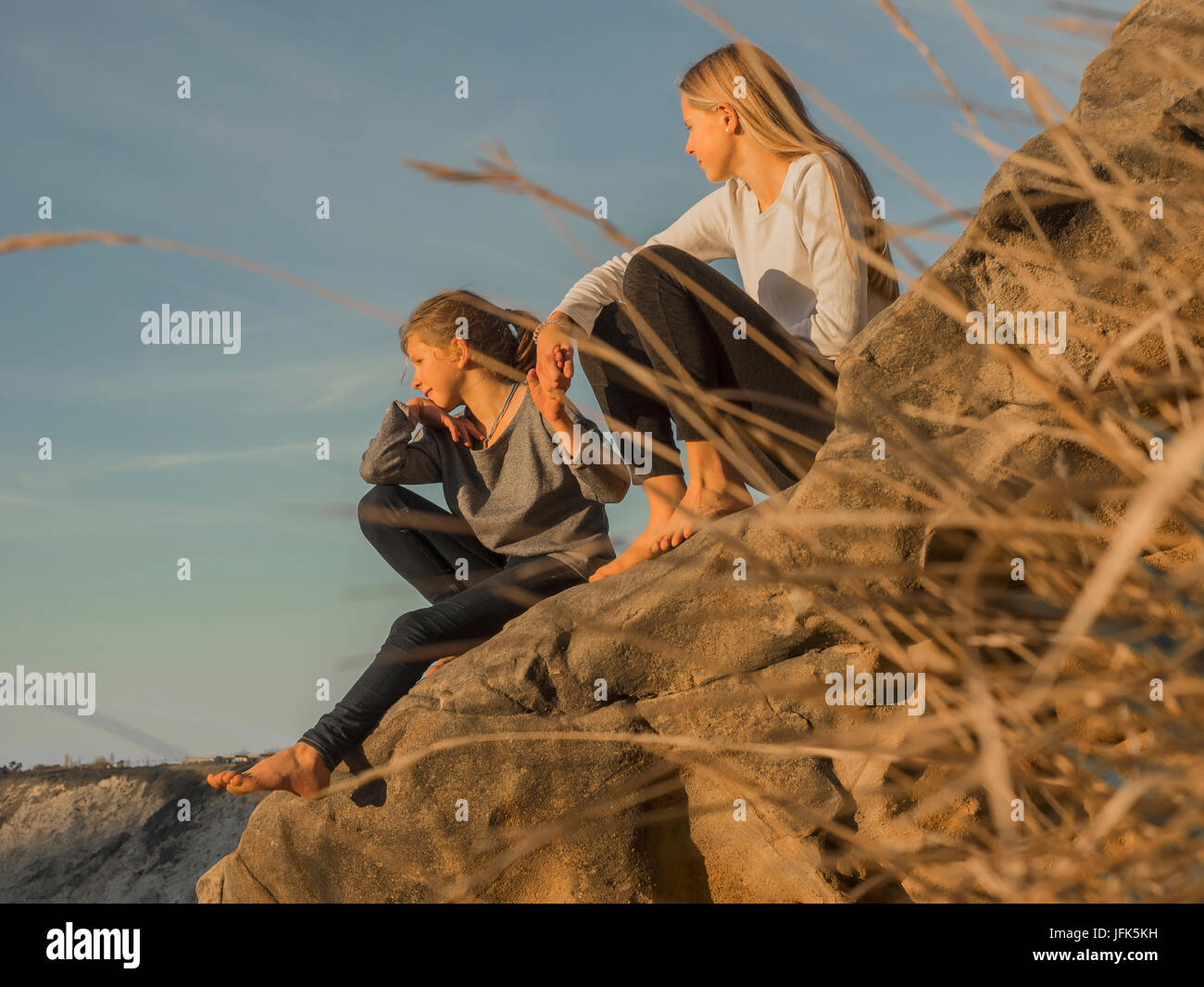 Girls sitting on rock hi-res stock photography and images - Alamy