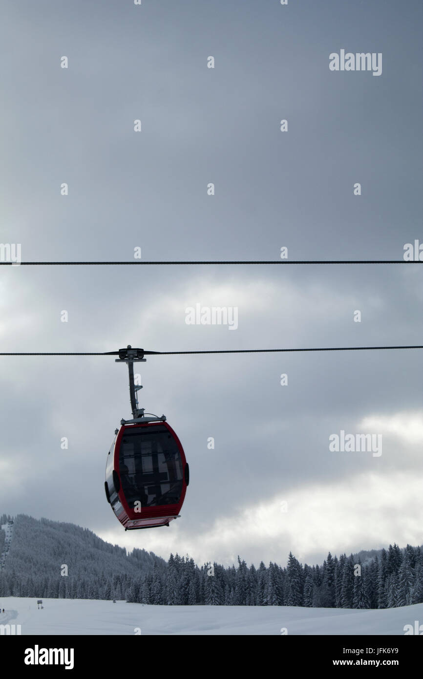 Overhead cable car over snowcapped mountain against cloudy sky Stock Photo