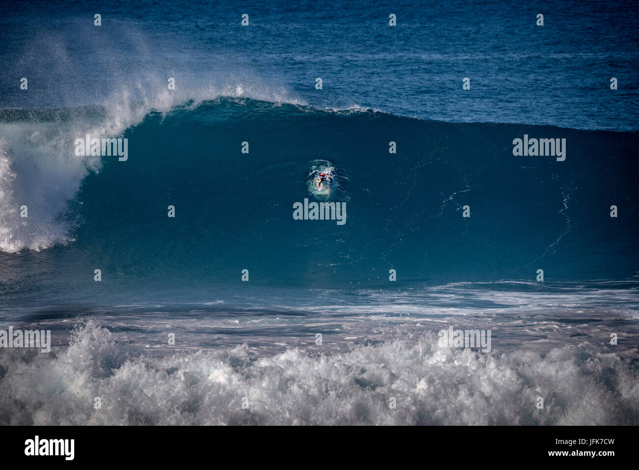 Surfer diving into wave at Hookaipa Beach. Maui, Hawaii Stock Photo