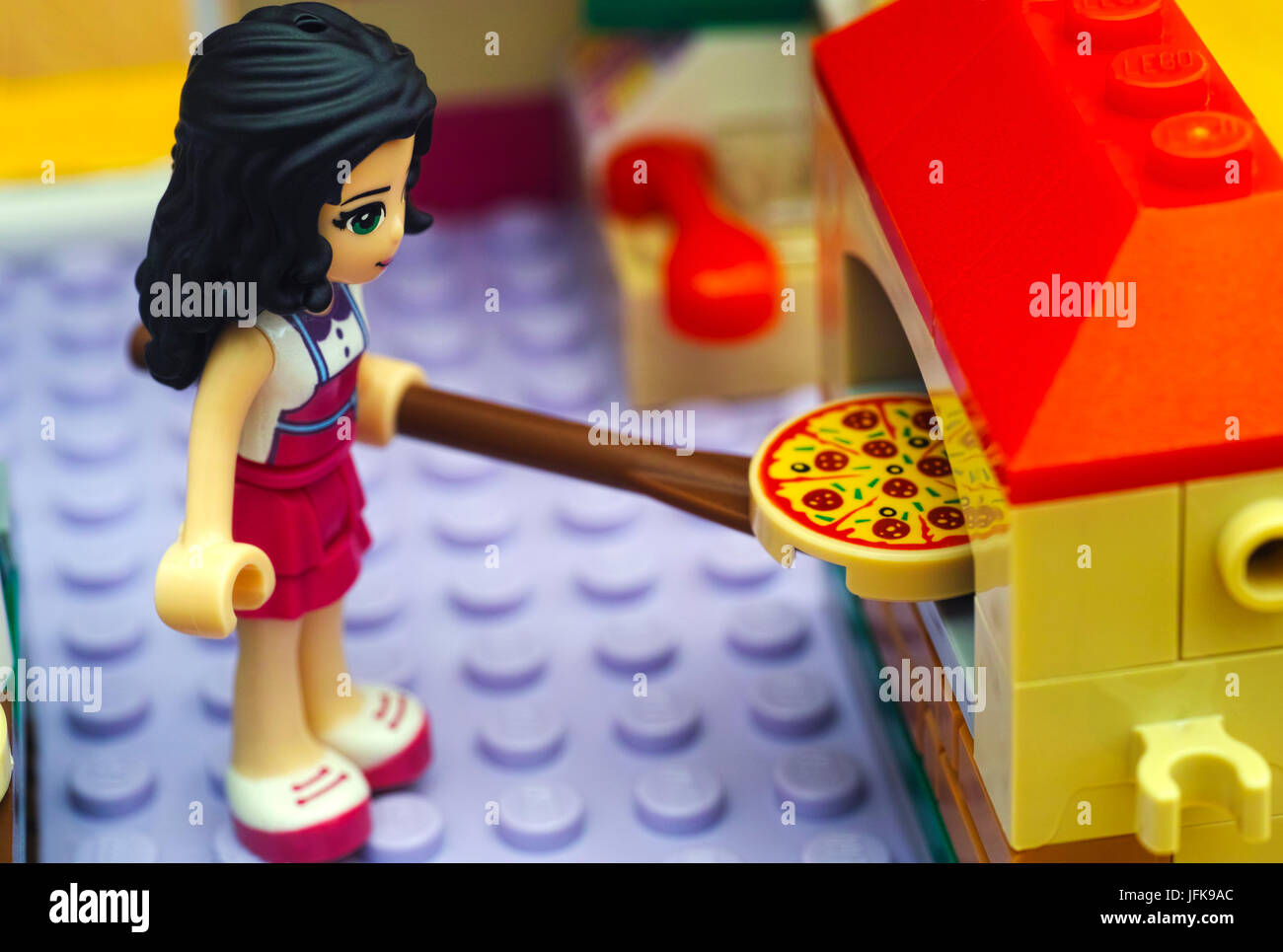 Tambov, Russian Federation - June 22, 2017 Lego girl use paddle to place pizza in the pizza oven. Studio shot. Stock Photo