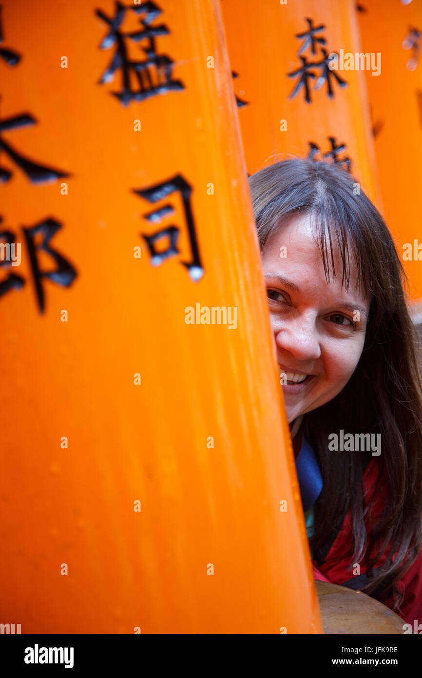 A happy tourist at the torii at Fushimi Inari in Kyoto, Japan Stock Photo