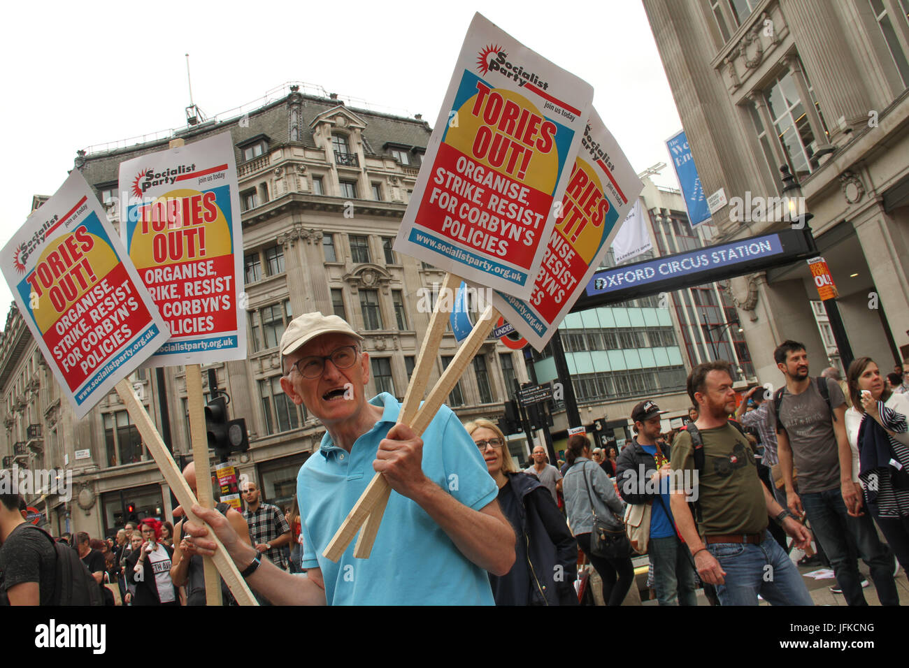 London, UK - 1 July 2017 - A demonstrator holds up placards by Oxford Street station ahead of the Tories Out march to Parliament Square on 1 July. Demonstrators took to the streets in a national demonstration demanding for an end of the Tory government. The demo began at Portland Place with demonstrators marching to Parliament Square for a rally. Credit: David Mbiyu/Alamy Live News Stock Photo