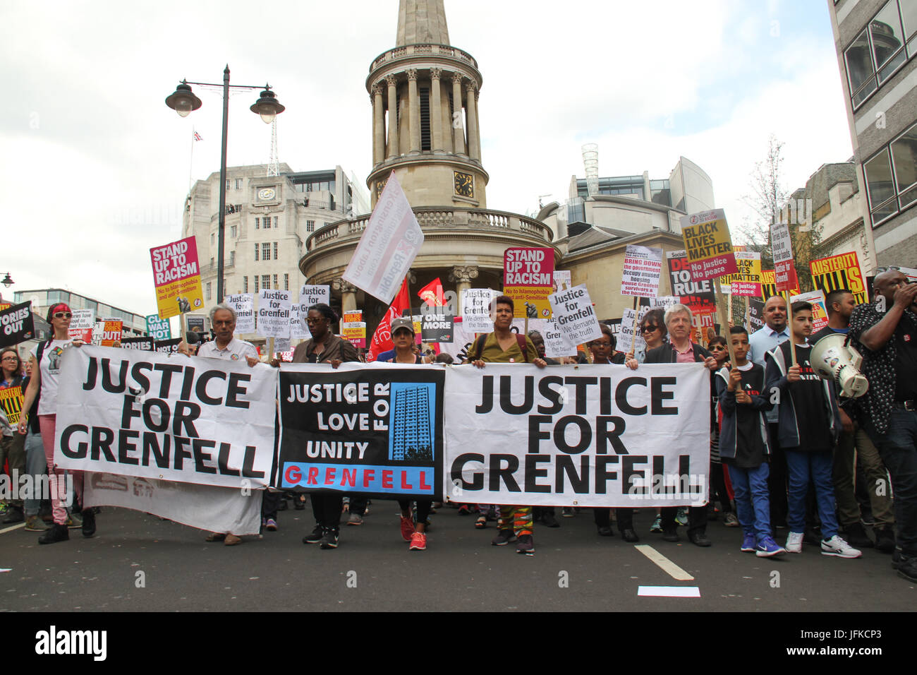 London, UK - 1 July 2017 - Demonstrators march holding a 'Justice for Grenfell' banner at the march in the Tories Out demo on 1 July .The demo began at Portland Place with demonstrators marching to Parliament Square for a rally. Credit: David Mbiyu/Alamy Live News Stock Photo