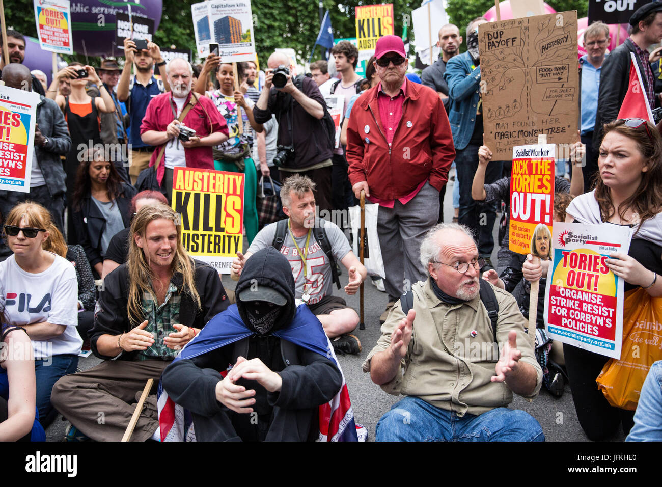 London, UK. 1st July, 2017. A few people stage a sit-down protest in front of Downing Street during the Not One More Day national demonstration organised by the People's Assembly Against Austerity in protest against continuing austerity, cuts and privatisation and to call for a properly funded health service, education system and housing. A minute's silence was also held for the victims of the fire at Grenfell Tower. Credit: Mark Kerrison/Alamy Live News Stock Photo