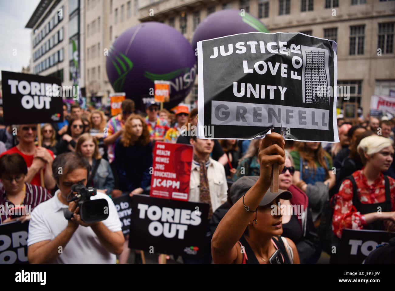 London, UK. 1st Jul, 2017. A protester holds up a 'Justice for Grenfell' sign during the Not One Day More demonstration against the Conservative government. Thousands of protesters marched from Regent Street to Parliament Square, with speechs from Diane Abbott, John McDonnell and Jeremy Corbyn. Credit: Jacob Sacks-Jones/Alamy Live News. Stock Photo