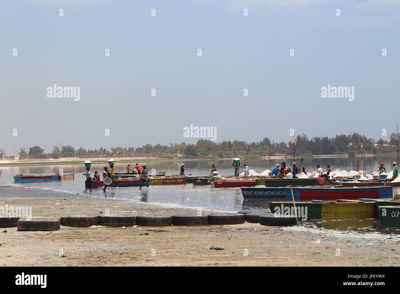 Salt workers and their boats on the shore of Lake Retba, Pink Lake, Lac Rose, outside Dakar, Senegal Stock Photo
