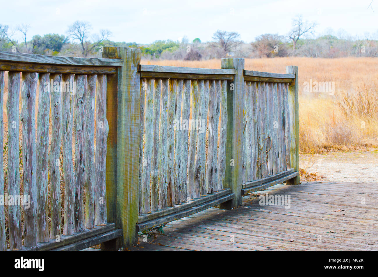 weathered fence near a field of prarie grass in Texas Stock Photo