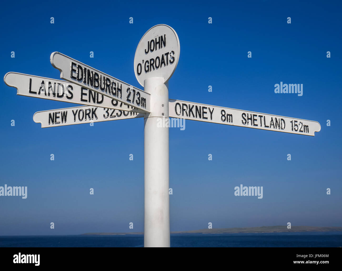 Signpost at John O'Groats against cloudless blue sky indicating miles to Edinburgh, New York, Orkney, Shetland and Lands End, Scotland, UK Stock Photo