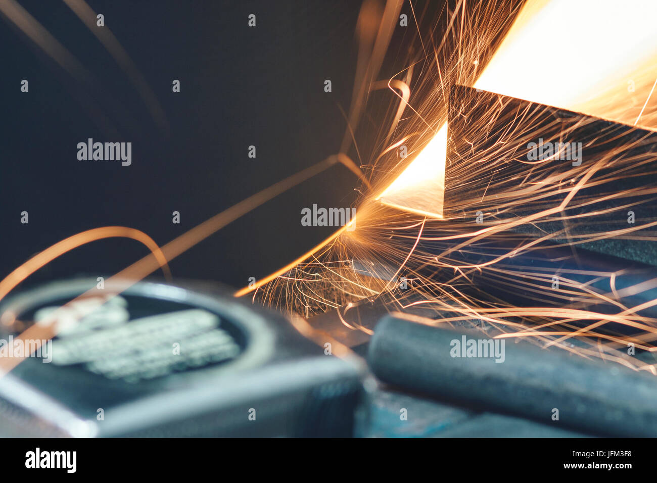 Cutting steel pipe with cutting machine and spreading sparks all around