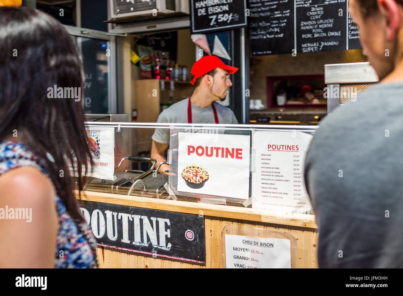 Montreal, Canada - May 28, 2017: Jean Talon market Poutine restaurant sign inside building closeup with chef in city in Quebec region Stock Photo