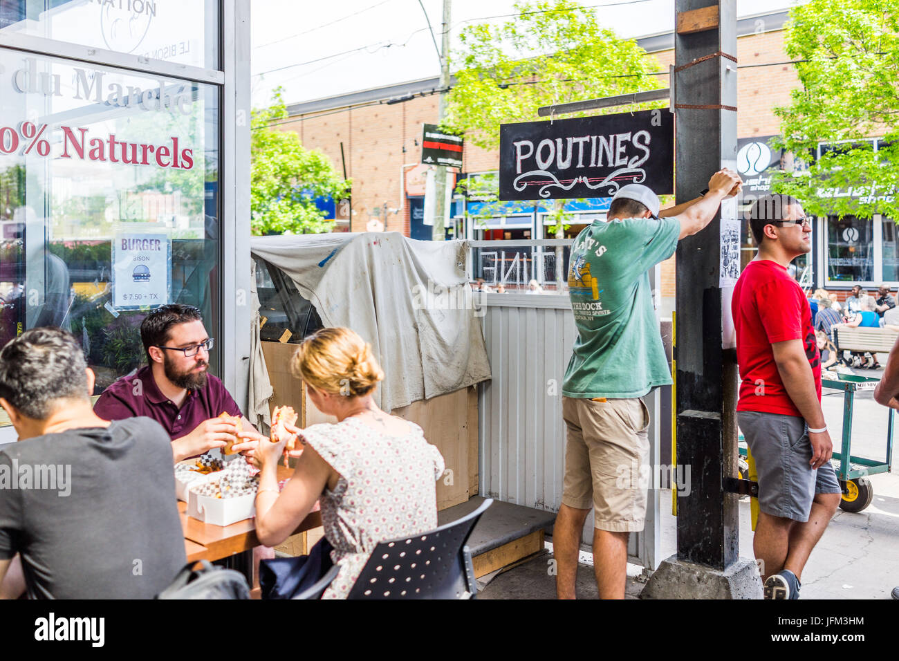 Montreal, Canada - May 28, 2017: Jean Talon market Poutine restaurant sign inside building with people eating at tables in city in Quebec region Stock Photo