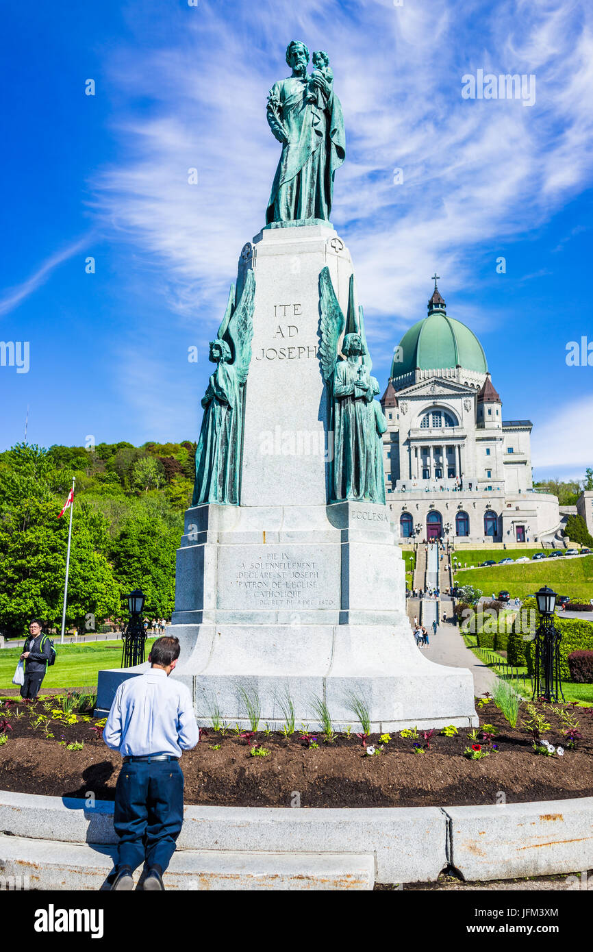 Montreal, Canada - May 28, 2017: St Joseph's Oratory on Mont Royal with man praying by statue in Quebec region city Stock Photo