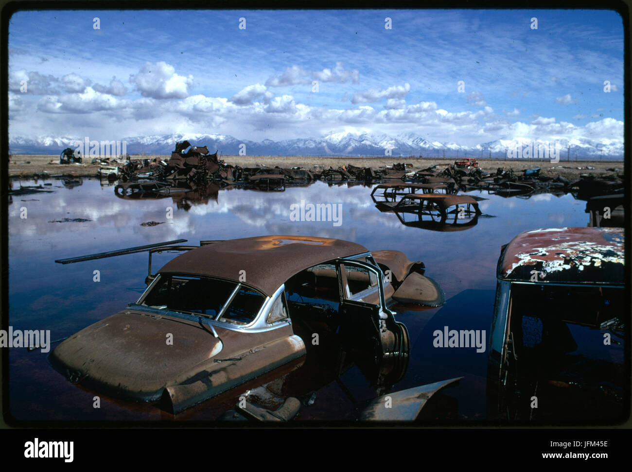 Abandoned automobiles and other debris clutter acid water and oil-filled five-acre pond. It was cleaned up under the Environmental Protection Agency supervision to prevent possible contamination of Great Salt Lake and a wildlife refuge nearby. Utah, April 1974. Stock Photo