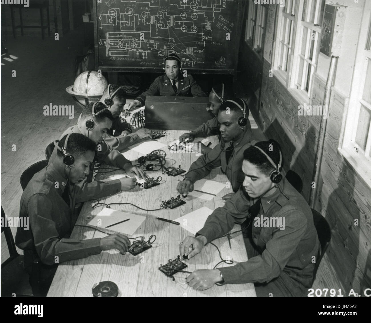 January 1942, Tuskegee, Alabama - Basic and advanced flying school for Negro Air Corps cadets. In the center is Capt. Roy F. Morse, Air Corps....He is teaching the cadets how to send and receive code. One the left from front to rear: James B. Knighten, Lee Rayford, and C.H. Flowers. On the right, George Levi Knox, Sherman White and Mac Ross. Stock Photo