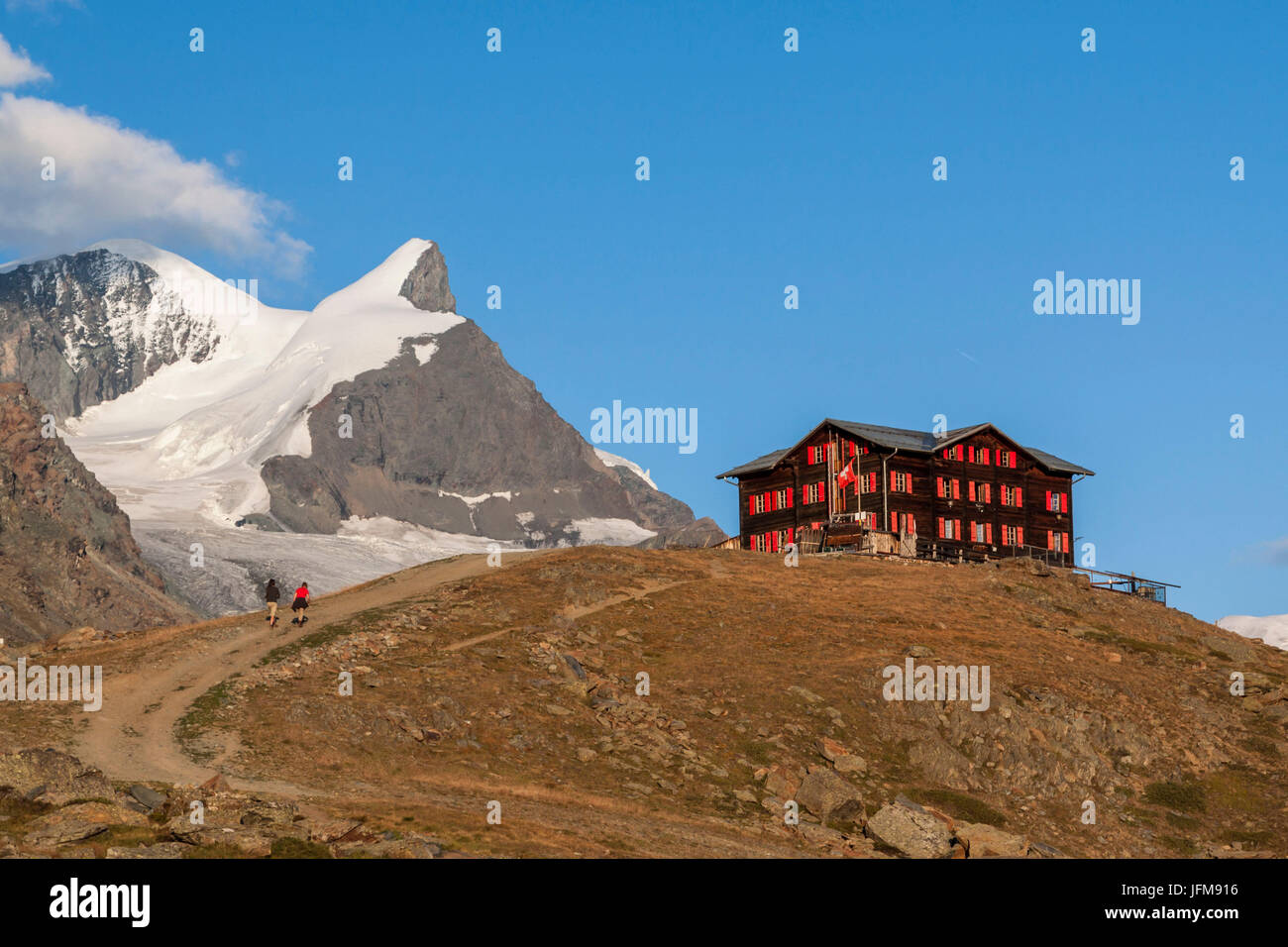 Hikers arriving at the shelter Fluhalp, Zermatt valley, Valais-Wallis Canton, Switzerland Stock Photo