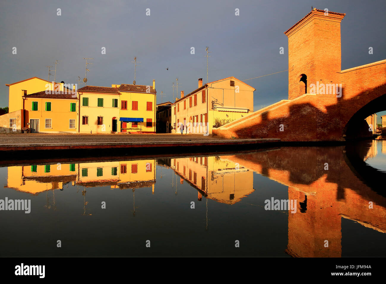 View of Comacchio at sunrise, with houses reflected in the canal, Ferrara district, Emilia Romagna, Italy Stock Photo