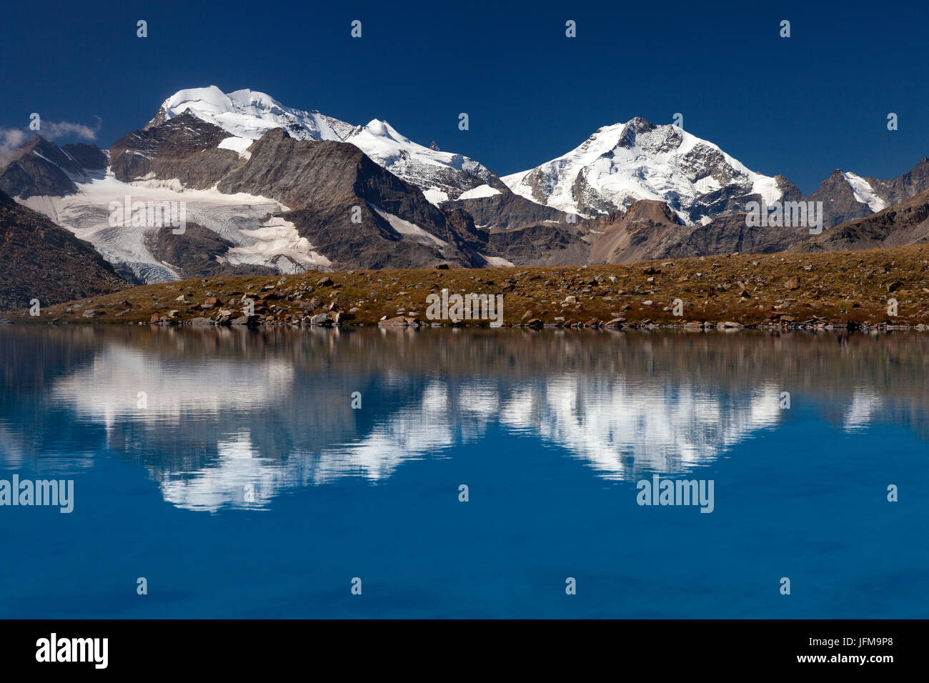 Piz Bernina reflection on Lago Vago, Livigno, Province of Sondrio, Lombardy, Italy Stock Photo
